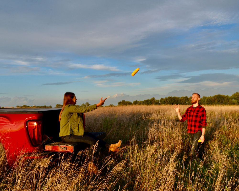 an engaged couple throwing corn